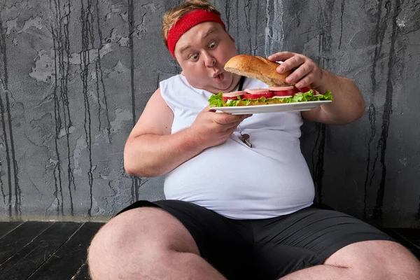 ショックを受けた太った男が大きなサンドイッチを — ストック写真