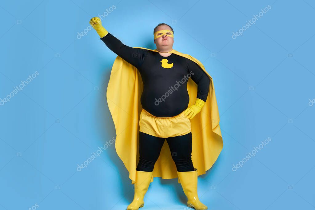 Superhero fat caucasian male in mask and protective gloves posing. man looks as Mr.Proper, going to clean everything on his way
