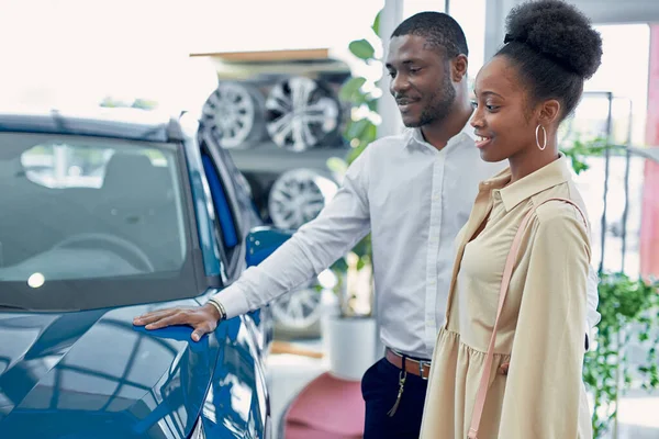 Stellen Sie sich vor, wir wären unterwegs. Porträt eines glücklichen afrikanischen Paares beim Auschecken eines Autos — Stockfoto