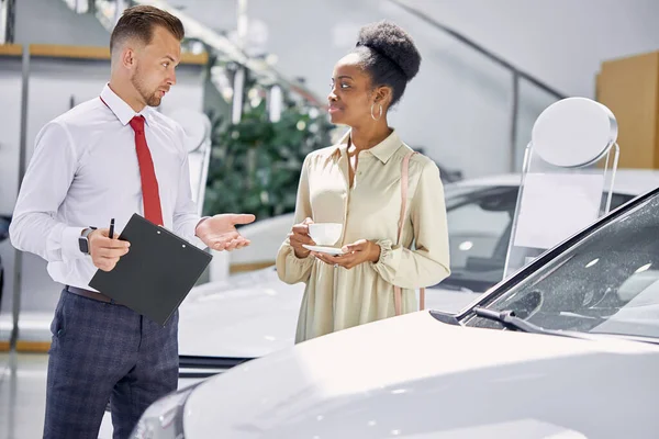 Concesionario de coches caucásicos explicando contrato de venta al cliente — Foto de Stock