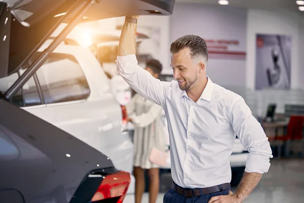 Mann öffnet Kofferraum in Autohaus — Stockfoto