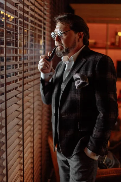 İyi giyimli, gözlüklü, tütün piposu içen olgun sakallı adam. — Stok fotoğraf