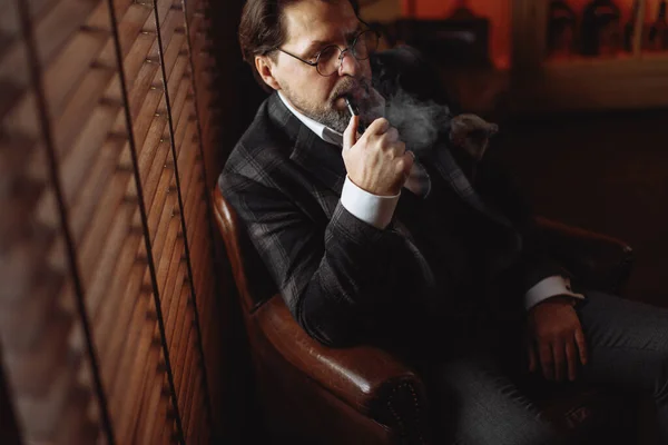 Reflexo bem vestido maduro barbudo homem em óculos fumar cachimbo de tabaco — Fotografia de Stock