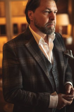 Şarap dolabının karşısında duran kendinden emin restoran sahibi.