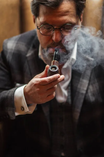 Riflettente uomo barbuto maturo ben vestito in occhiali da fumo tabacco pipa — Foto Stock