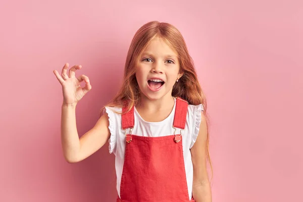 Allt är ok gest av liten kaukasiska flicka isolerad över rosa bakgrund — Stockfoto