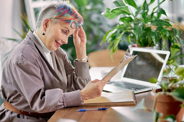 Senior de negócios senhora ler documento em seu local de trabalho — Fotografia de Stock