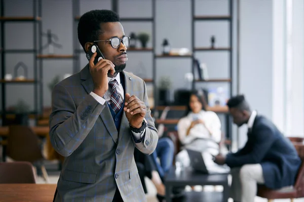仕事中に携帯電話で話す忙しい若いアフリカ人男性 — ストック写真