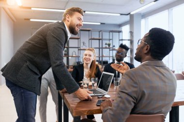 İş adamları işte. Bir grup çok ırklı insan Kafkasyalı işadamını dinliyor