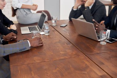 Masada oturan iş adamlarının elleri.