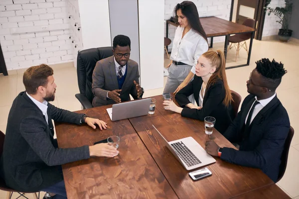 Jovem treinador de negócios africano conversando com jovens empresários entusiastas — Fotografia de Stock