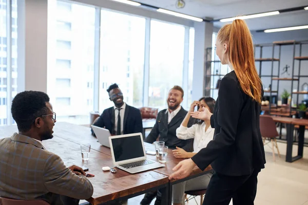 Auburn femme leader chevelu expliquant idée d'affaires aux représentants étrangers — Photo