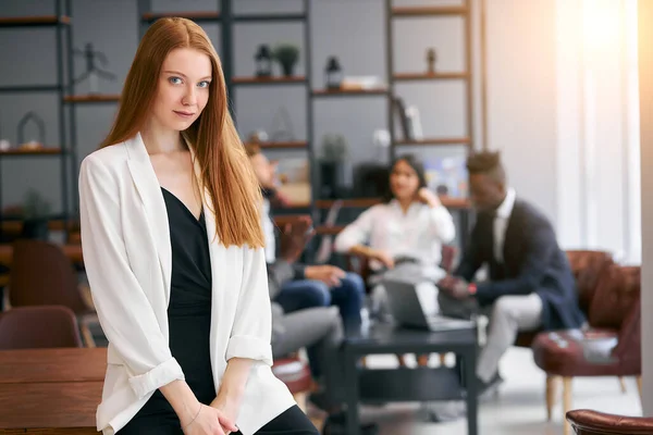 Retrato de linda joven dama de negocios sonriendo y mirar a la cámara en un ambiente de oficina — Foto de Stock