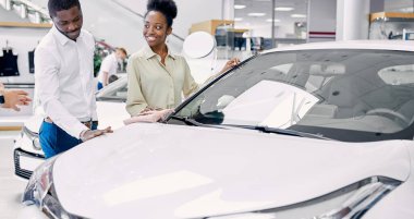 Bizi yolda hayal et. Mutlu bir Afrikalı çiftin portresi bir arabayı kontrol ediyor.