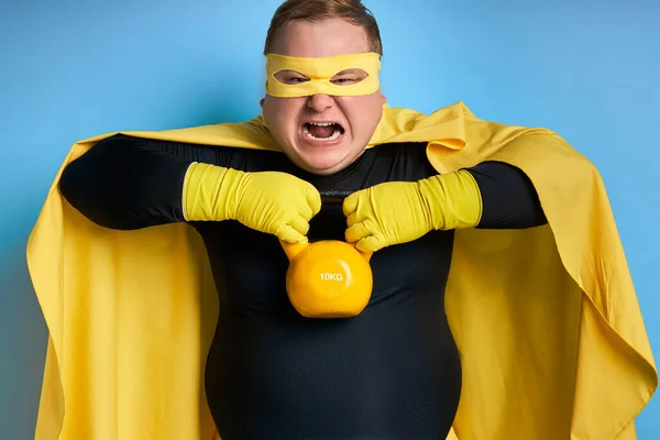 Жирний потужний супергерой людина показує, наскільки він сильний — стокове фото