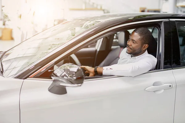 Erfolgreicher Geschäftsmann sitzt am Steuer eines neuen Autos — Stockfoto