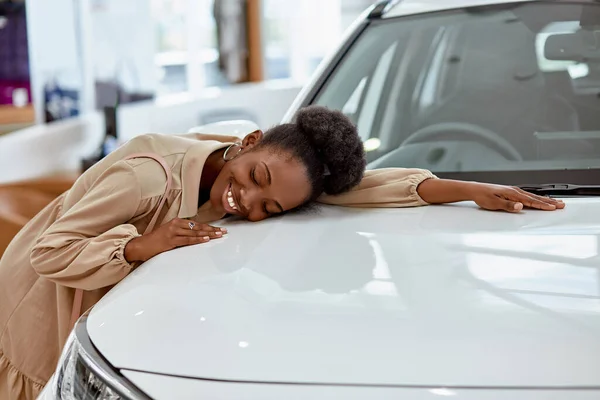 Lächelnde schwarze Dame umarmt ihr neues Auto — Stockfoto