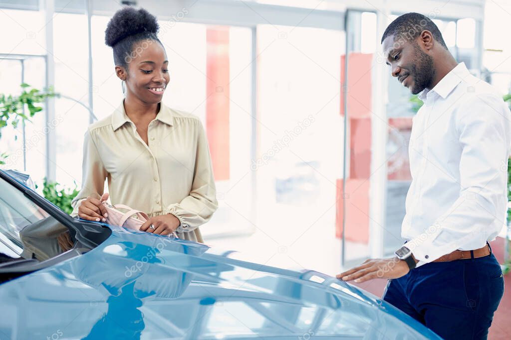 black couple in contemplation before making purchase in cars showroom