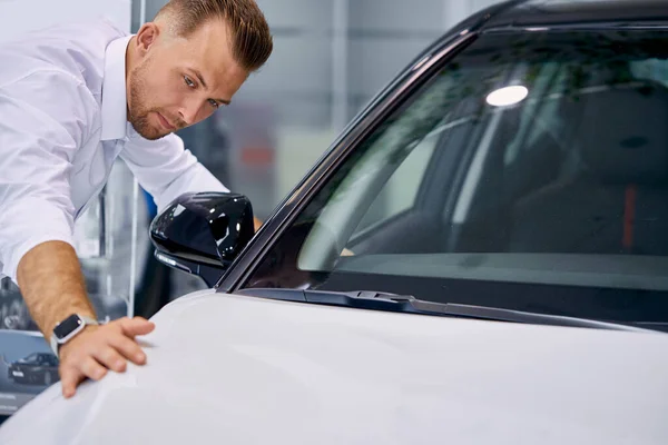 Красивий білий бізнесмен оглядає автомобіль перед покупкою — стокове фото