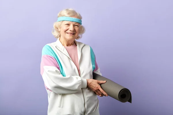 Glückliche ältere Frau in der Hand einer Yogamatte — Stockfoto