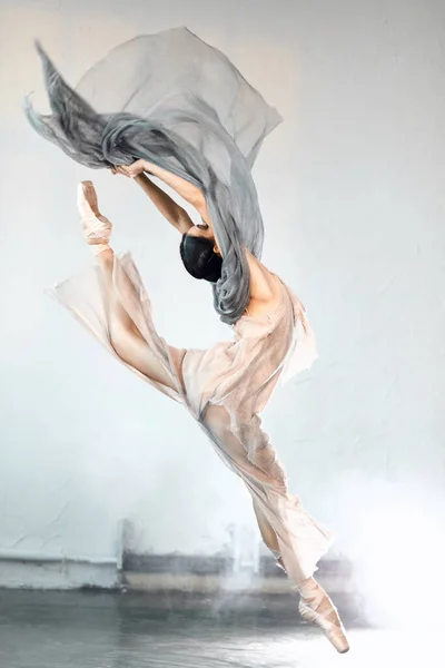 Giovane ballerina che salta su uno sfondo fumoso leggero. — Foto Stock