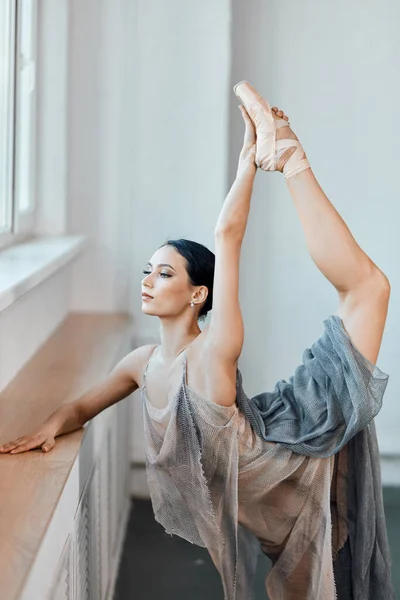 Bailarina se dobra para trás, de pé em uma perna fazendo alongamento, levantando a perna para cima . — Fotografia de Stock