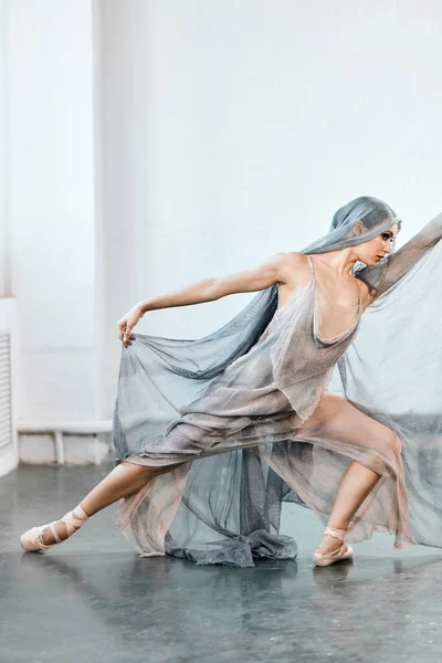 Bailarina de ballet flexible estirándose en el estudio con luz oscura — Foto de Stock