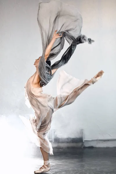 Joven bailarina de ballet saltando sobre un fondo ahumado . — Foto de Stock