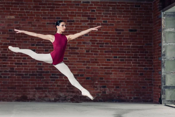 Gymnastka dělá rozdělení při skákání — Stock fotografie