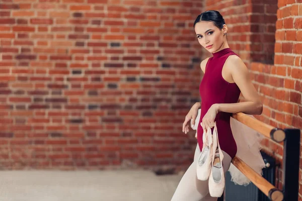 Uma bela bailarina jovem magro segurando sapatos pontiagudos para dançar — Fotografia de Stock