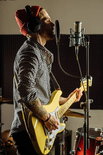 Guitarrista contemporaneamente tocar guitarra e cantar uma música — Fotografia de Stock