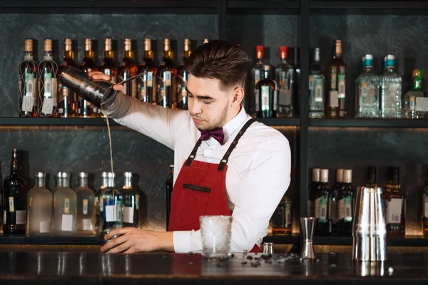 Μπάρμαν ρίχνει φρέσκο κοκτέιλ από σέικερ στο ποτήρι στον πάγκο μπαρ — Φωτογραφία Αρχείου