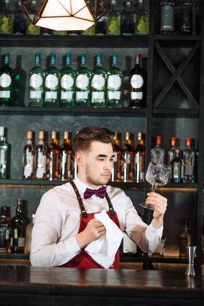 Camarero de pie en el mostrador de bar, vasos de limpieza con toalla — Foto de Stock