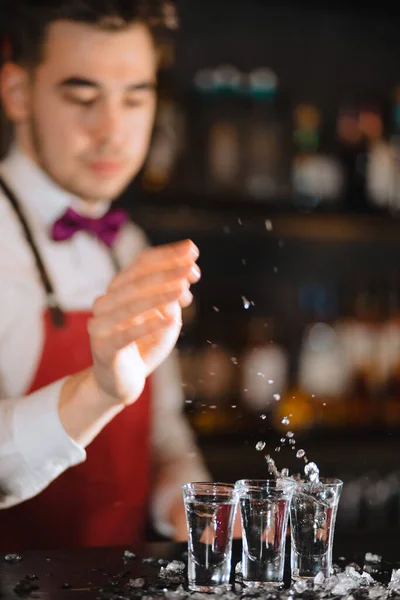Μπάρμαν στο λευκό πουκάμισο προσθέτοντας πάγο σε ποτήρι κοκτέιλ στον πάγκο μπαρ — Φωτογραφία Αρχείου