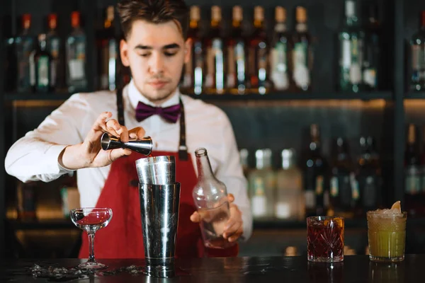 Barman vertiendo cóctel fresco de agitador en el vaso en el mostrador del bar —  Fotos de Stock