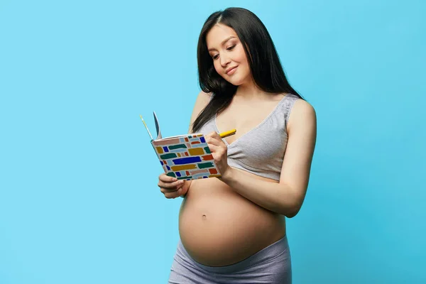 Smiling pregnant woman in headphones dancing in studio over purple  background. Stock Photo by ©ufabizphoto 265681264