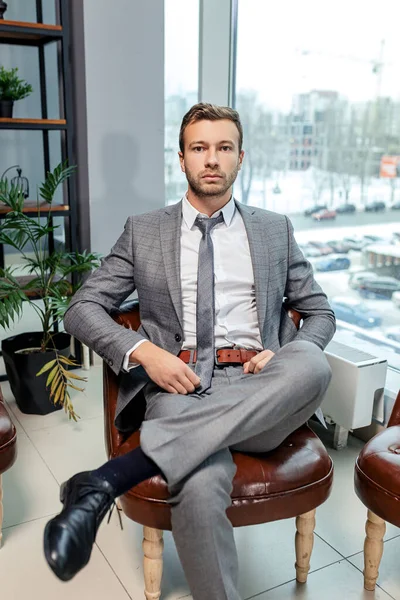 Молодий чоловік в смокінгу сидить у власному офісі — стокове фото