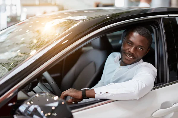 Rico homem africano tentar-se ao volante do novo automóvel — Fotografia de Stock