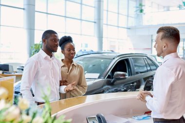 Hoş bir satıcı, müşterileri galeride karşılar.