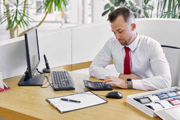 portrait of serious manager using calculator