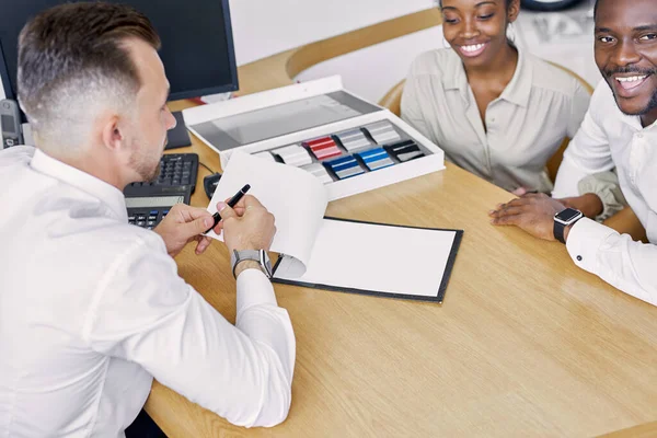 professional sales agent and clients have friendly conversation in dealership