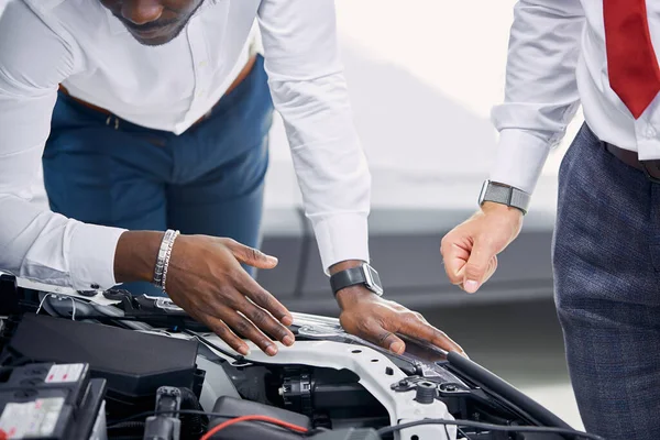 Cliente y vendedor abrió el capó del coche y discutir todos los matices relativos al coche — Foto de Stock