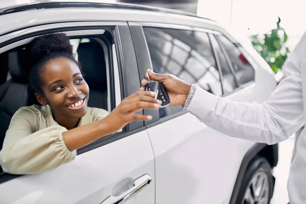 Retrato de boa aparência afro senhora recebendo chaves de carro — Fotografia de Stock