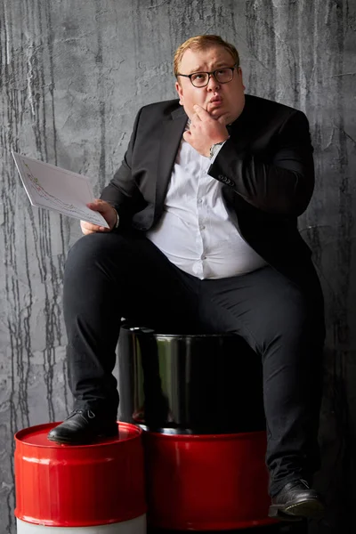 Sorprendido empresario gordo está comprobando noticias sobre los recursos petroleros — Foto de Stock