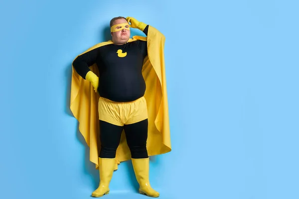 Riflessivo grasso supereroe isolato su sfondo blu — Foto Stock