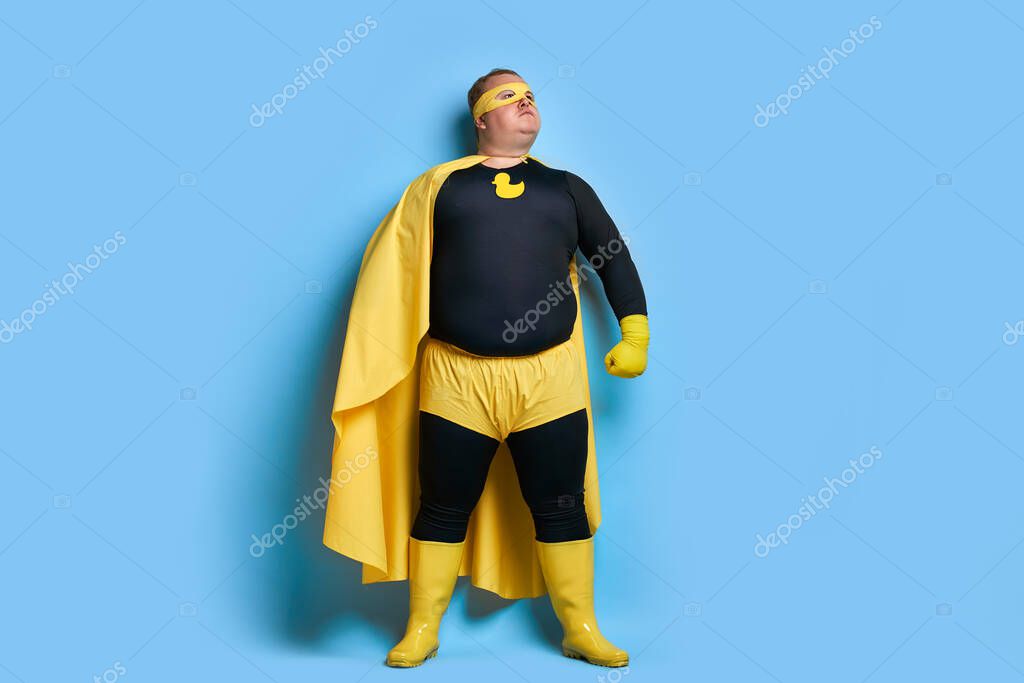 Superhero fat caucasian male in mask and protective gloves posing. man looks as Mr.Proper, going to clean everything on his way
