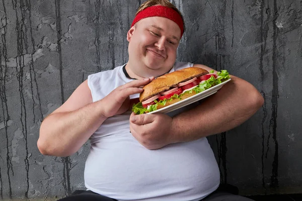 Słodkie śmieszne tłuszcz człowiek głaskanie kanapka w ręce — Zdjęcie stockowe