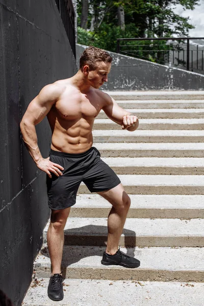 Corredor atlético sem camisa caucasiano que sobe e desce as escadas da cidade. — Fotografia de Stock