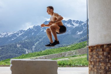 Erkek atlamacı patlayıcı güç sıçraması yapıyor, uygun spor yapıyor.