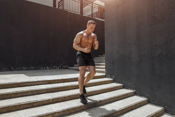 Pernas atléticas de jovem desportista com músculos lenço afiados correndo em degraus escada correndo em treino de treinamento urbano ou competição corredor em fitness e conceito de estilo de vida saudável — Fotografia de Stock